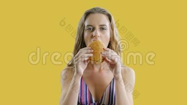 年轻<strong>瘦瘦</strong>的漂亮女人正在吃黄色或橙色背景的汉堡包。 <strong>瘦</strong>女孩饿了
